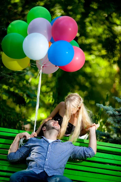Jeune couple aimant avec des ballons sur fond naturel — Photo