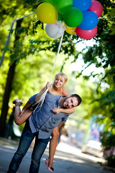 Νέοι αγαπώντας ζευγάρι με μπαλόνια σε φυσικό φόντο — Φωτογραφία Αρχείου