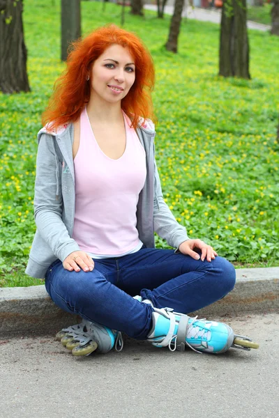 Расслабляющая рыжая девушка на коньках — стоковое фото