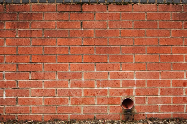 Bakstenen muur met drainage gat of buis — Stockfoto