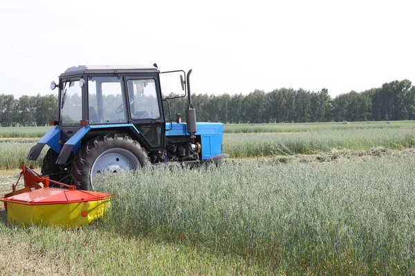 Traktor i ett fält, jordbruks-scen i sommar — Stockfoto