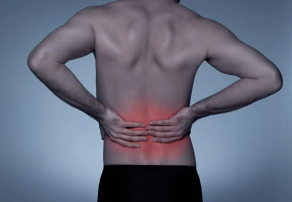 Молодой человек с болью в спине — стоковое фото
