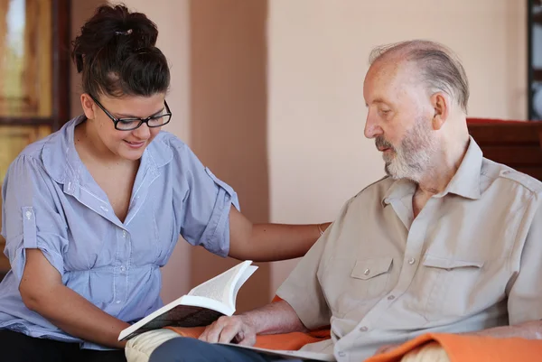 Betreuerin liest Senioren vor — Stockfoto