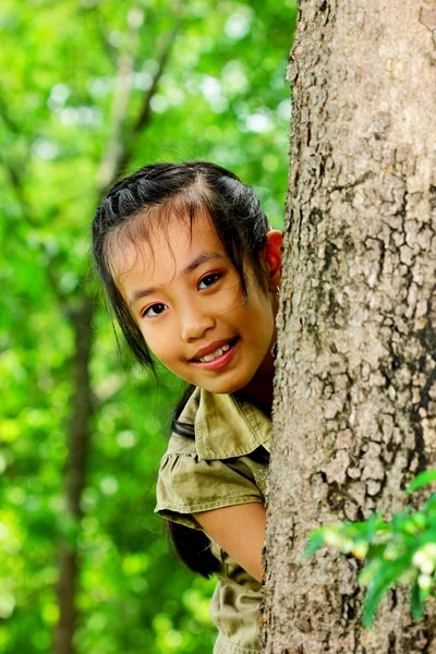 La ragazza stava giocando dietro un grande albero — Foto Stock
