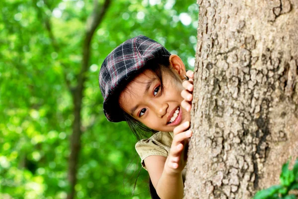 Девушка играла за большим деревом — стоковое фото