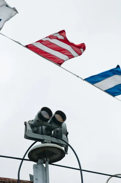 Корабельные полевые стекла и сигнальные флаги — стоковое фото