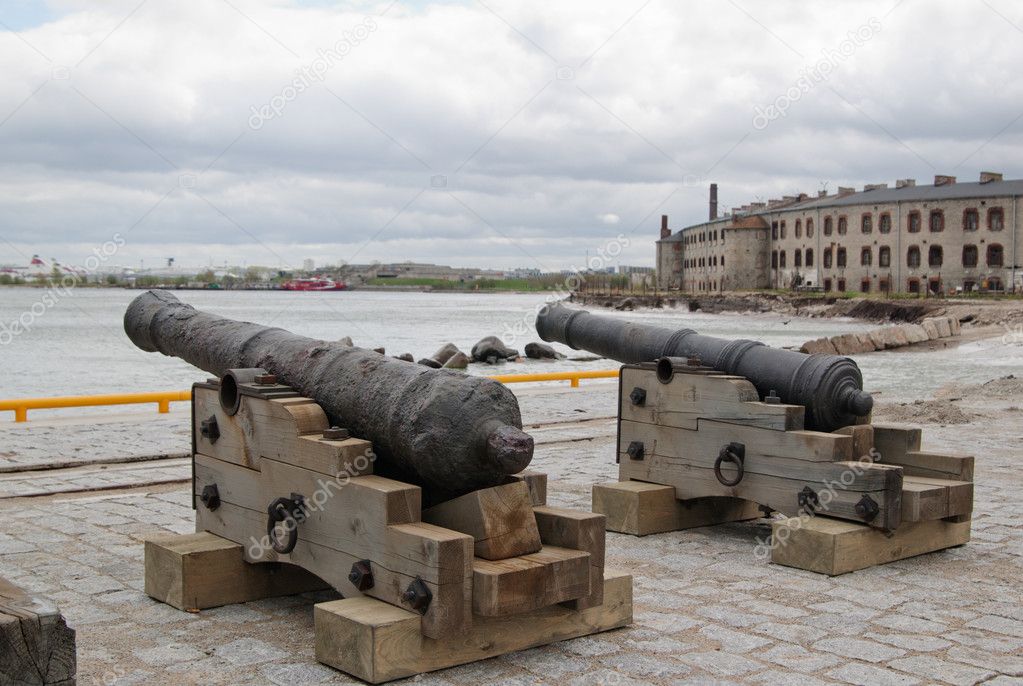 Ancient guns on a background of a fortress at the sea