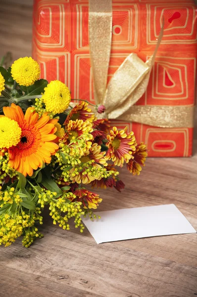 Caixa de presente e um buquê de flores — Fotografia de Stock