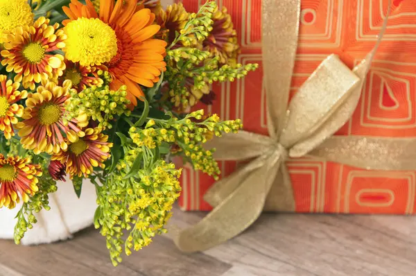 Geschenkdoos en een boeket van bloemen — Stockfoto