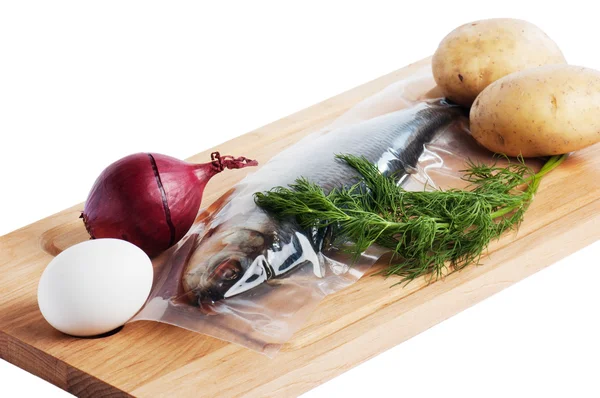 Vegetables and a salty herring on a kitchen board — Stock Photo, Image