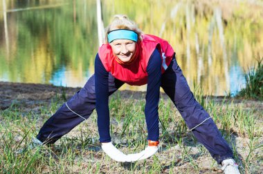 Woman making of the stretching in full nature clipart