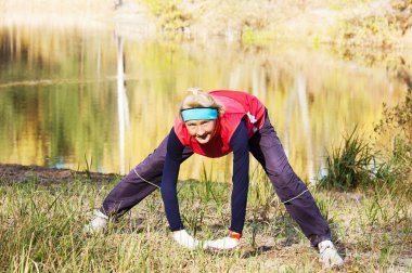 Woman making of the stretching in full nature clipart