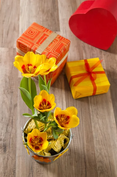 C'est des tulipes jaunes rouges et des boîtes-cadeaux, un gros plan — Photo