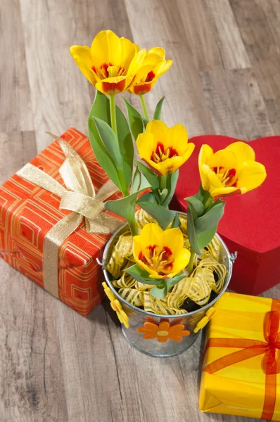 È tulipani gialli rossi e scatole di regalo, un primo piano — Foto Stock
