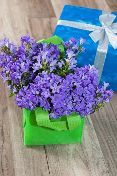 Ramo de primavera campanula azul y caja de regalo, un primer plano — Foto de Stock