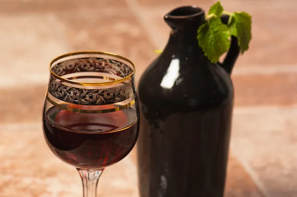 stock image Black jug for wine and a glass of red wine