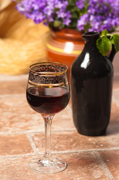 stock image Black jug for wine and a glass of red wine