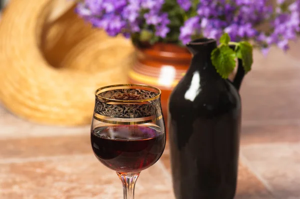 stock image Black jug for wine and a glass of red wine