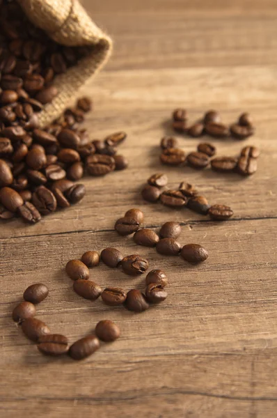 stock image Grains of coffee on a wooden surface