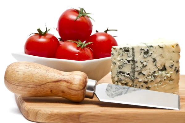 Tábua de cortar com queijo azul e tomate cereja — Fotografia de Stock