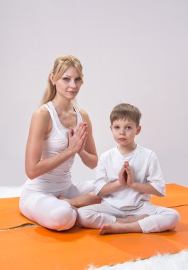 güzel, genç bir anne oğluyla birlikte yoga uygulamaları