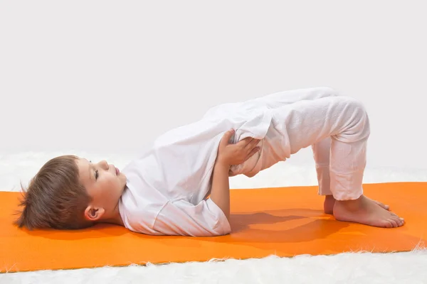 Baby Yoga. Der kleine Junge macht Sport. — Stockfoto