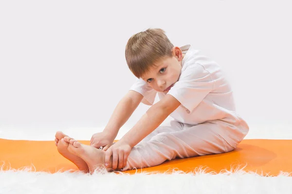 Baby yoga. de kleine jongen oefent. — Stockfoto
