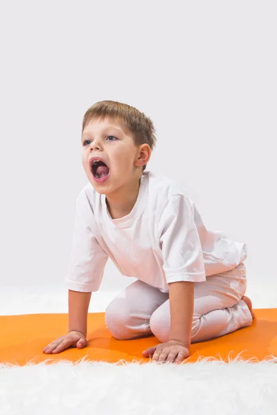 Baby Yoga. Der kleine Junge macht Sport. — Stockfoto