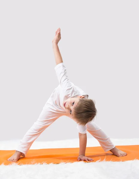 Детская йога. Маленький мальчик делает упражнения . — стоковое фото