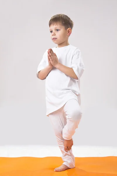 Детская йога. Маленький мальчик делает упражнения . — стоковое фото