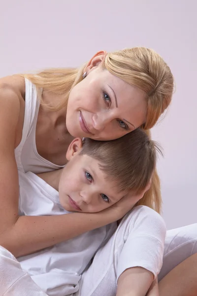 Eine schöne junge Mutter mit ihrem Sohn ruht sich beim Yoga aus — Stockfoto