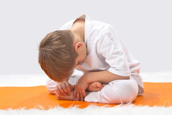Kinderen van yoga. de kleine jongen oefent. — Stockfoto