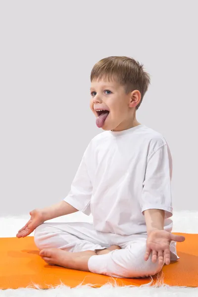 Детская йога. Маленький мальчик делает упражнения . Лицензионные Стоковые Фото