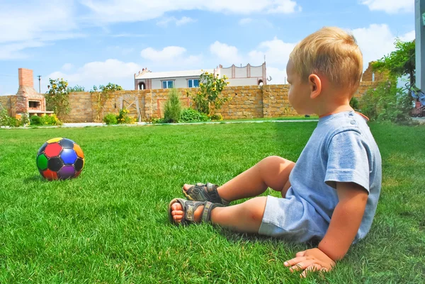Ungen med bollen på gräset — Stockfoto