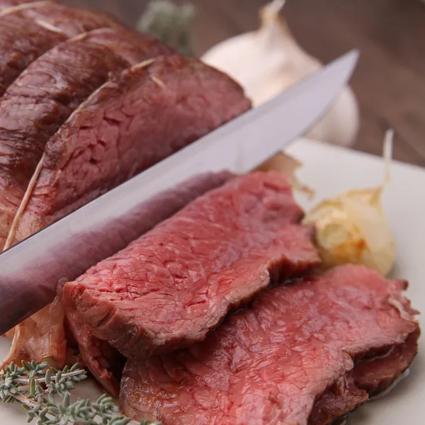 Roast beef with knife — Stock Photo, Image