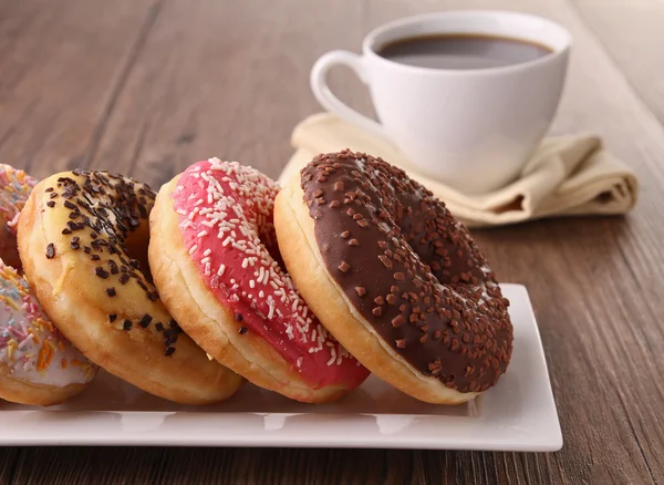 Donuts en koffiebeker — Stockfoto