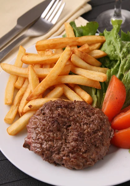 Bife grelhado, batatas fritas e legumes — Fotografia de Stock