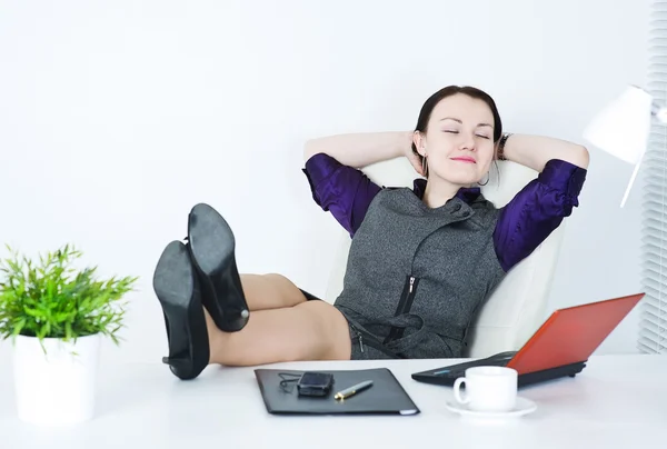 Mujer de negocios relajarse con las piernas en la mesa — Foto de Stock