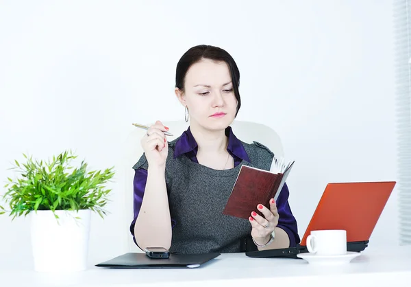 Femme d'affaires sérieuse avec ordinateur portable et stylo — Photo