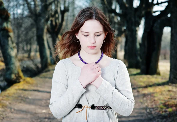 Молодая женщина в винтажном платье молится — стоковое фото