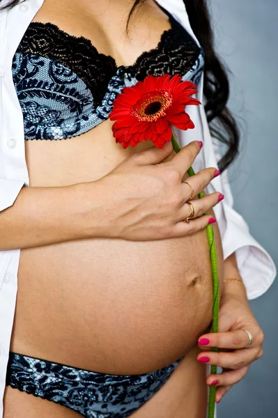 妊娠中の女性の花を持つ — ストック写真