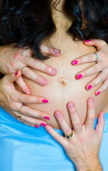 Casal grávida segurando barriga por mãos — Fotografia de Stock