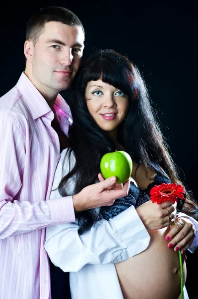 Pregnant couple with apple and flower — Stock Photo, Image