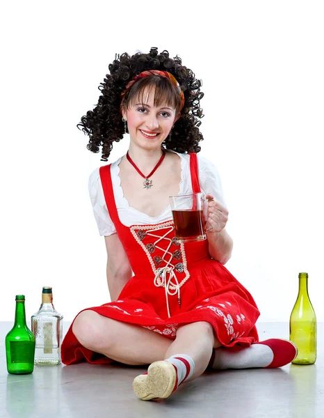 Красивая женщина с кружкой пива и пустыми бутылками — стоковое фото