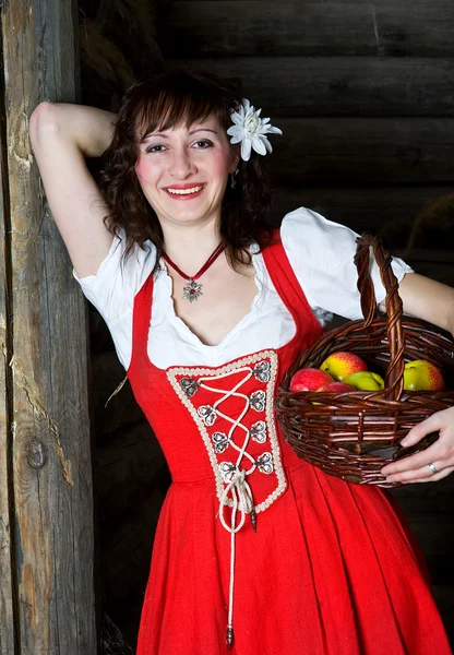 Mulher sorridente com cesta e maçãs — Fotografia de Stock