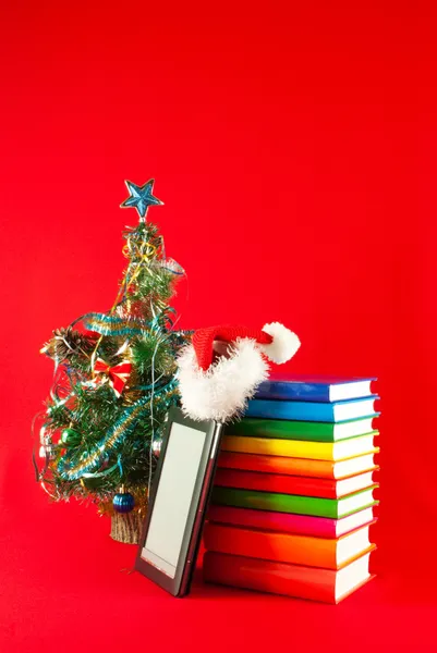 Lector electrónico de libros con pila de libros sobre fondo rojo — Foto de Stock