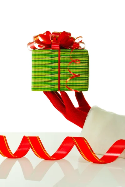 Mão do Papai Noel segurando um presente de Natal contra fundo branco — Fotografia de Stock