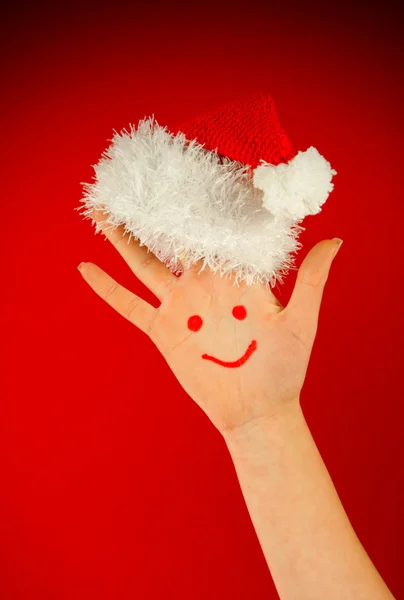 Člověk je palm s úsměvem na ní klobouk Santa — Stock fotografie