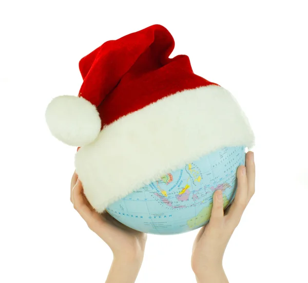 Stock image Hands holds globe with Santa's hat over white background