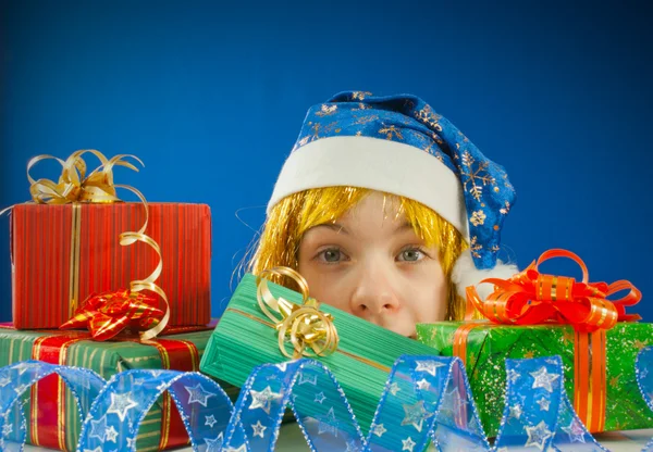 Sorprendido adolescente chica mirando desde detrás de los regalos de Navidad —  Fotos de Stock